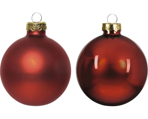 Deux boules de Noël rouges en verre, une mate et une brillante, avec des calottes et des œillets dorés.