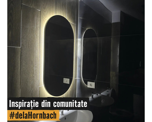 Miroir de salle de bain ovale moderne avec rétroéclairage LED sur un mur aspect bois au-dessus d'un lavabo blanc.