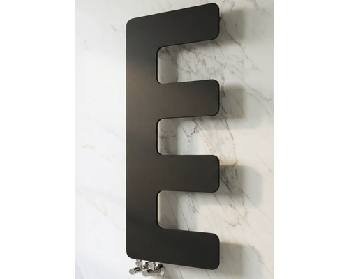 Radiateur de salle de bain design en forme de E en métal noir mat, monté sur un mur avec effet marbre.