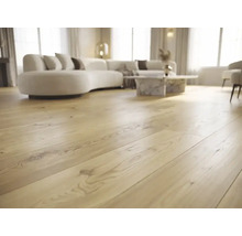 Holzboden im Landhausdielen-Stil in einem modernen, lichtdurchfluteten Wohnzimmer mit geschwungenem Sofa und Marmortisch.