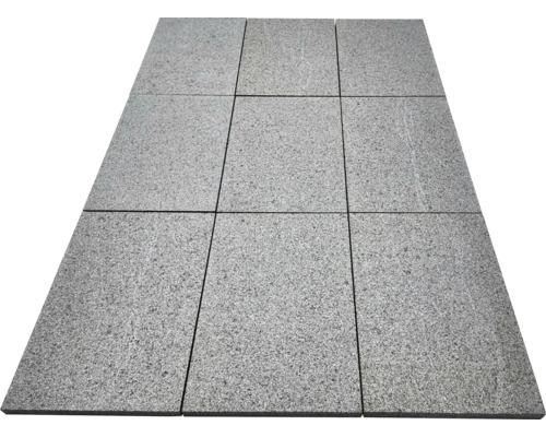Neuf dalles de terrasse rectangulaires en granit avec une surface structurée, posées selon un motif de trois sur trois.