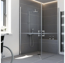 Cabine de douche d'angle PMR avec portes vitrées battantes dans une salle de bains moderne en carrelage gris.