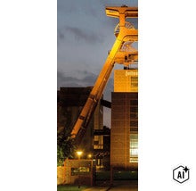 Le chevalement illuminé de la mine Zollverein à Essen au crépuscule. (Image AI modified or generated)