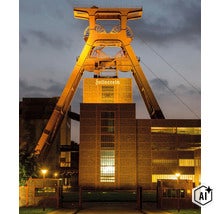 Chevalement de la mine de charbon de Zollverein à Essen illuminé au crépuscule, avec l'inscription Zollverein éclairée. (Image AI modified or generated)