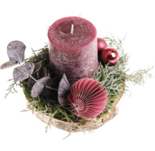 Centre de table de Noël avec bougie pilier sur un disque en bois décoré d'eucalyptus et de boules de Noël