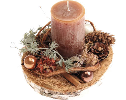 Décoration de table de Noël avec une bougie pilier sur un disque de bois, ornée de pommes de pin, de boules de Noël et de bâtons de cannelle.