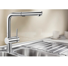 Mitigeur de cuisine moderne avec douchette extractible en métal sur un évier.