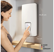 Femme utilisant un chauffe-eau instantané électronique avec écran tactile et dimensions, label de qualité Made in Germany