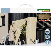 Une femme utilise une housse de protection hivernale Windhager Easy Up XXL sur une terrasse pour protéger les plantes du froid.