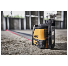 DeWalt Linienlaser auf einem Betonboden projiziert eine rote Laserlinie in einer Baustelle.