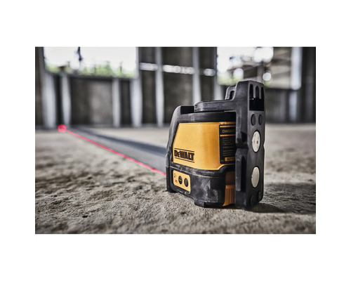 DeWalt Linienlaser auf einem Betonboden projiziert eine rote Laserlinie in einer Baustelle.