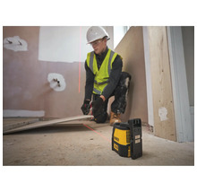 Handwerker verwendet Dewalt Kreuzlinienlaser zur präzisen Ausrichtung von Bodenfliesen auf einer Baustelle.