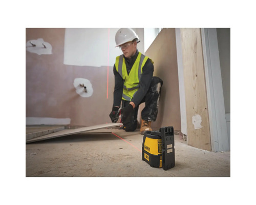 Handwerker verwendet Dewalt Kreuzlinienlaser zur präzisen Ausrichtung von Bodenfliesen auf einer Baustelle.