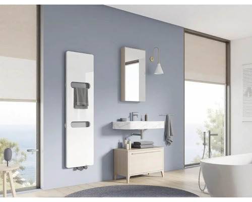 Salle de bain moderne avec radiateur sèche-serviettes vertical, vasque en marbre, armoire de toilette, meuble et baignoire îlot près de la fenêtre.