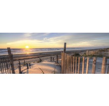 Plage avec clôture en bois au coucher du soleil