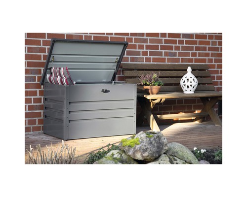 Coffre de jardin ouvert avec coussins à côté d''un banc de jardin