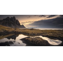 Landschaft mit Bergen, Wasser und Gras