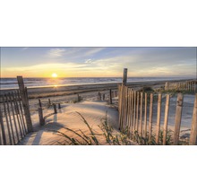 Strandlandschaft mit Sanddünen und Holzzaun bei Sonnenuntergang