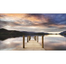 Steg aus Holz an einem See unter bewölktem Himmel