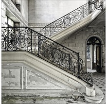 Escalier avec rampes ornementales dans un bâtiment abandonné