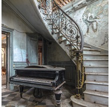 Ein verlassenes Gebäude mit Treppe und Klavier in einem beschädigten Zustand.