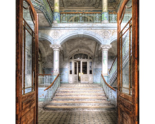 Innenansicht eines verlassenen Gebäudes mit Treppe und offenen Türen