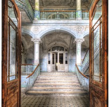 Innenraum eines verlassenen Gebäudes mit Treppe und offenen Türen