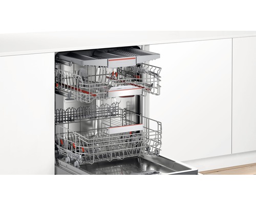 Lave-vaisselle ouvert avec deux paniers à vaisselle dans une cuisine claire