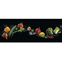 Arrangement aus verschiedenen Gemüsesorten und Kräutern mit Wassertropfen auf schwarzem Hintergrund.