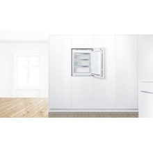 Congélateur intégré avec porte ouverte dans une cuisine lumineuse