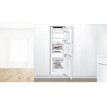 Réfrigérateur-congélateur intégré avec portes ouvertes dans une cuisine lumineuse et spacieuse