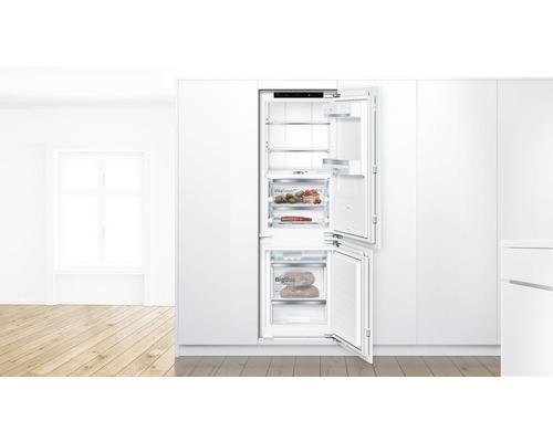 Réfrigérateur-congélateur intégré avec portes ouvertes dans une cuisine lumineuse et spacieuse