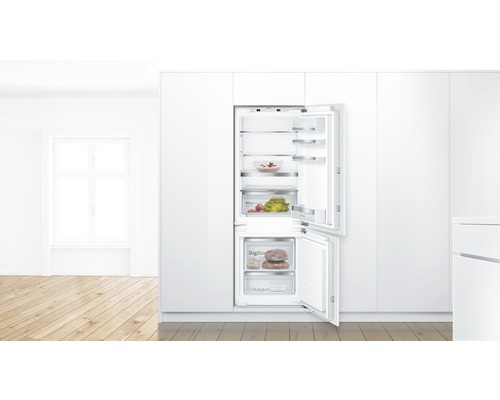 Eingebauter Kühlschrank mit geöffneter Tür, mit Lebensmitteln gefüllt