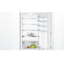 Geöffneter Kühlschrank mit Glasablagen und Gemüsefach