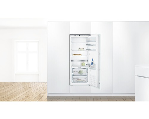 Réfrigérateur intégré avec porte ouverte dans une cuisine lumineuse