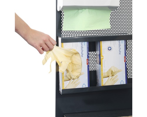 Une personne prend des gants en latex dans un distributeur
