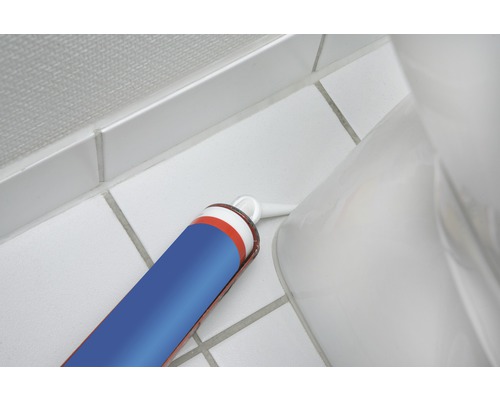 Cartouche de mastic silicone sanitaire à côté des toilettes sur des carreaux de salle de bain