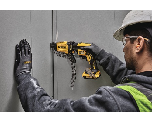 Artisan fixant des plaques de plâtre avec une visseuse à magasin DeWalt