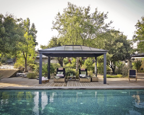 Pavillon Palram – Canopia Dallas 4900 488 x 364 cm anthracite Un jardin avec un pavillon, deux chaises longues et une piscine
