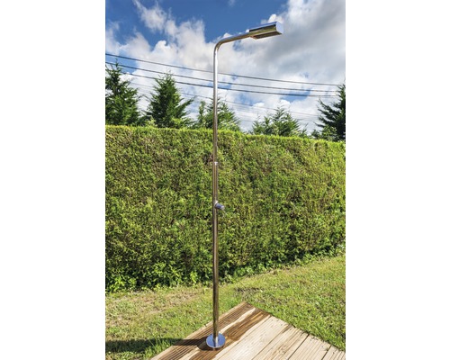 Douche d''extérieur en acier inoxydable sur une plateforme en bois dans le jardin