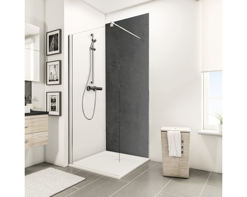 Cabine de douche avec receveur de douche, robinetterie de douche et panier à linge dans une salle de bain.