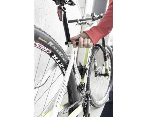 Gros plan d''un vélo dont la tige de selle est réglée avec un outil.