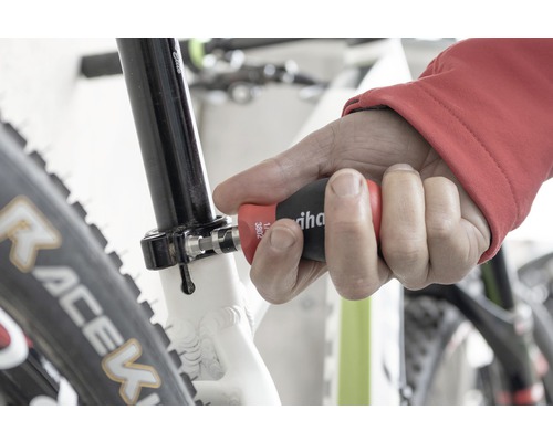 Un homme utilise un tournevis Wiha sur un vélo.