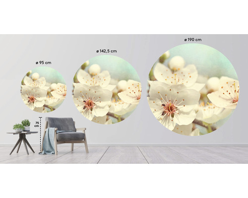 Drei runde Wandbilder mit Blumenmotiven in verschiedenen Größen über einem Sessel und einem Tisch.