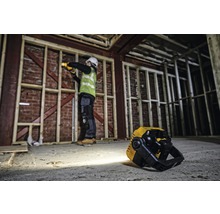 Scène de chantier avec un ouvrier travaillant avec une lampe à batterie