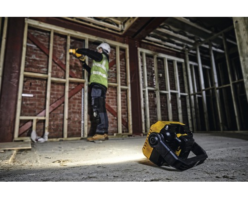 Scène de chantier avec un ouvrier travaillant avec une lampe à batterie