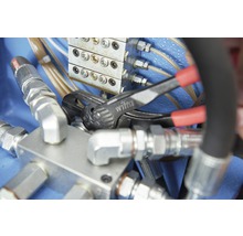 Eine Rohrzange der Marke Wiha wird an einer Hydraulikarmatur verwendet.