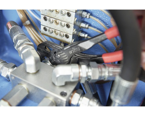 Une pince multiprise de la marque Wiha est utilisée sur un raccord hydraulique.