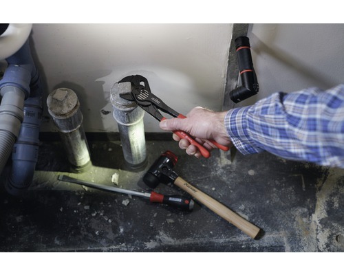 Installation d''une canalisation d''eaux usées avec pince multiprise, marteau et tournevis