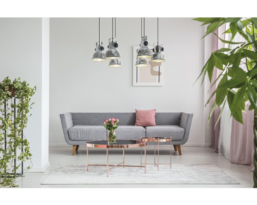 Wohnzimmer mit grauem Sofa, Couchtischen, Hängeleuchten und Zimmerpflanzen